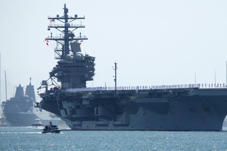 The USS Ronald Reagan, a Nimitz-class nuclear-powered super carrier, is followed by the USS Somerset as it departs for Yokosuka, Japan from Naval Station North Island in San Diego, California August 31, 2015. The Reagan is replacing the USS George Washington as part of a complicated three-carrier swap that exchanges crews for ships, saving the Navy millions in moving costs. REUTERS/Mike Blake