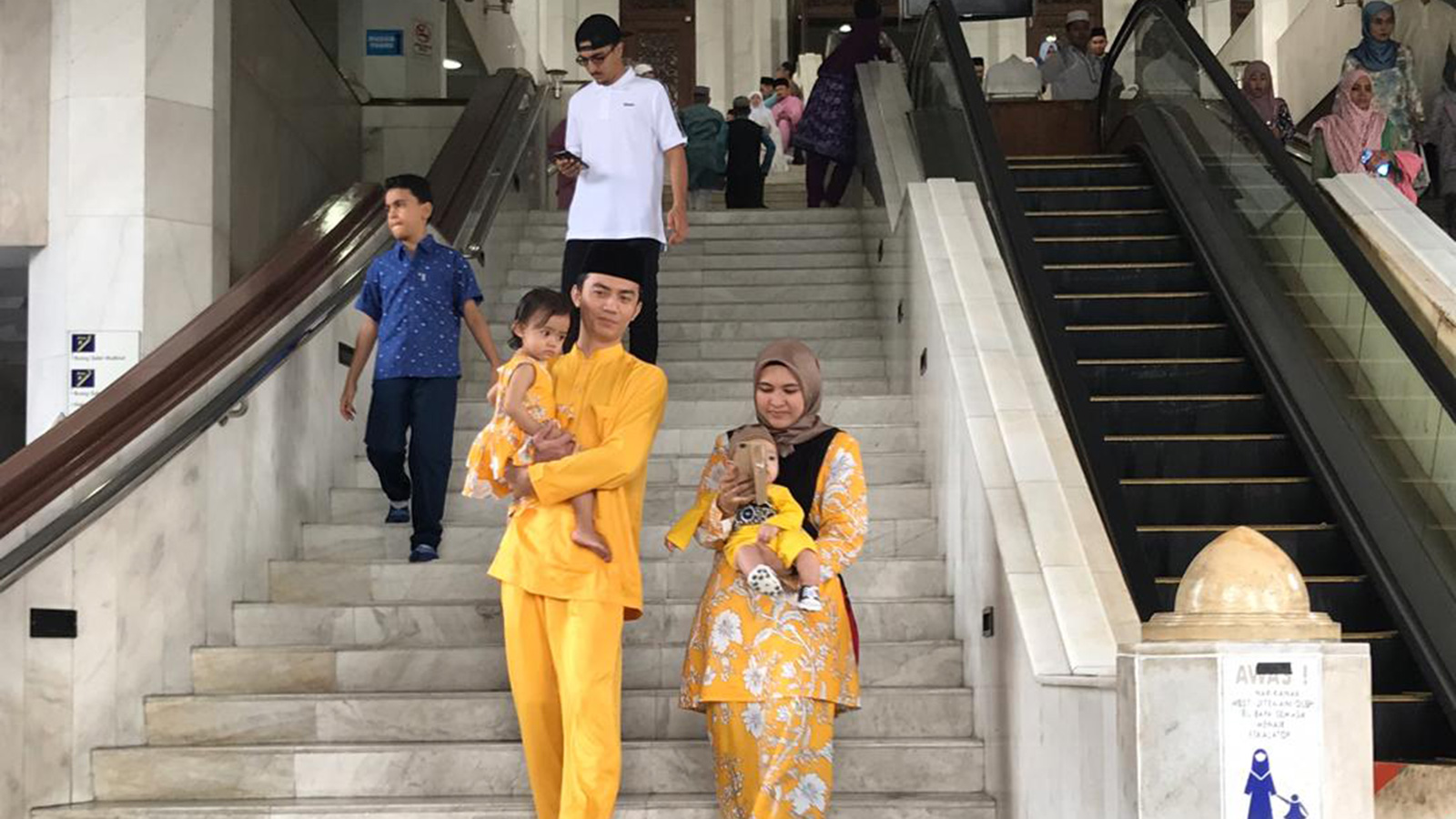 ‪العائلة الماليزية تحرص على توحيد زيها في العيد‬ (الجزيرة)