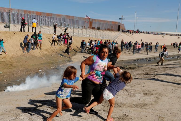 Maria Meza (C), a 40-year-old migrant woman from Honduras, part of a caravan of thousands from Central America trying to reach the United States, runs away from tear gas with her five-year-old twin daughters Saira Mejia Meza (L) and Cheili Mejia Meza (R) in front of the border wall between the U.S. and Mexico, in Tijuana, Mexico, November 25, 2018. Reuters Photographer Kim Kyung-Hoon: