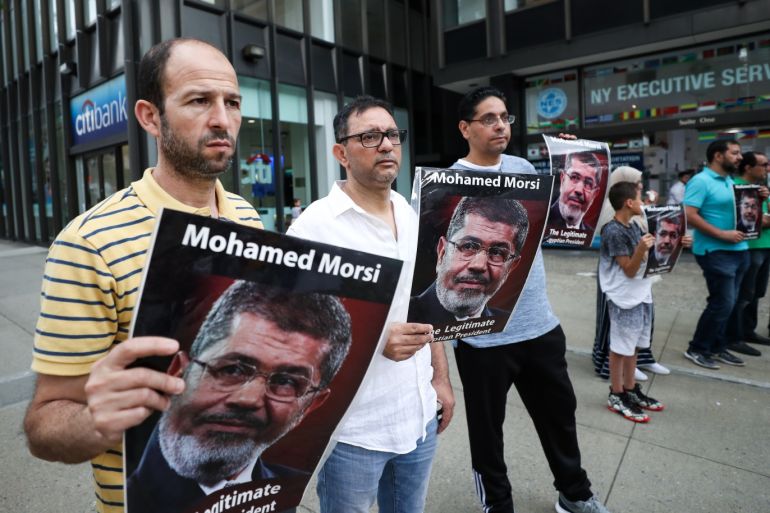 Demonstration for Mohamed Morsi in New York- - NEW YORK, USA - JUNE 17 : People carry images of Egypt's first popularly elected president Mohamed Morsi, who reportedly died from a heart attack on Monday at a court session, during a protest against the military government in Egypt outside the Consulate General of Egypt in New York, United States on June 17, 2019.