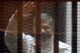 Egypt's ex-President Morsi dies during trial- - CAIRO, EGYPT - (ARCHIVE) : A file photo dated February 15, 2015 shows Ousted Egyptian President Mohamed Morsi standing inside a glass defendant's cage during first session in the trial where Morsi and 10 other co-defendants face on charges of spying for Qatar, in Cairo, Egypt. Egypt’s first democratically-elected president, Mohamed Morsi, 67, died Monday during a court trial on espionage charges.