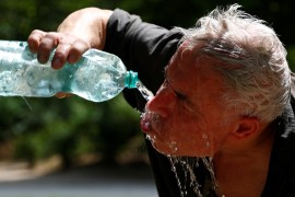 A man cools off with a bottle of water on a hot summer day in a park in Brussels, Belgium, June 24, 2019. REUTERS/Francois Lenoir