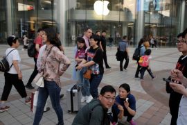 People walk past an Apple store in Wangfujing shopping street in Beijing, China May 15, 2019. REUTERS/Thomas Peter