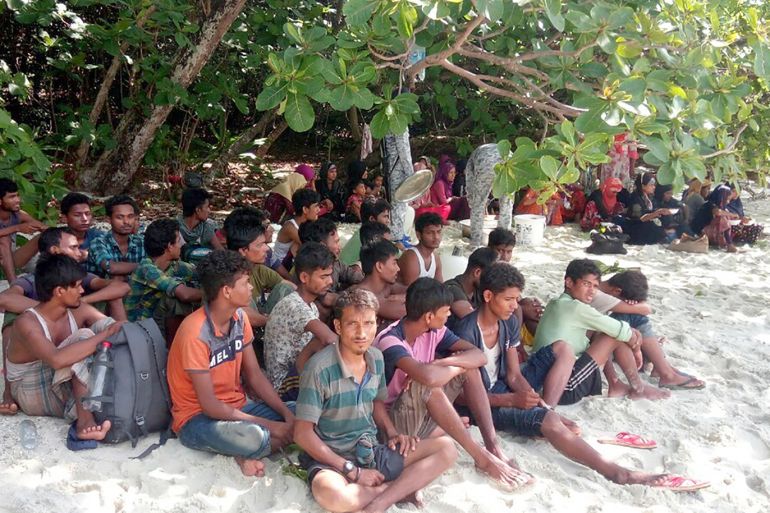epa07640884 Thai security officials stand guard as they provide food to Rohingya refugees after they were found stranded on a beach at Koh Rawi island, Satun province, southern Thailand, 11 January 2019. Sixty-four Muslim Rohingya refugees from Myanmar including women and children were found stranded on a beach in southern Thailand after their boat, believed to be en route to seeking sanctuary, was damaged as they ran out of fuel and food. EPA-EFE/STR
