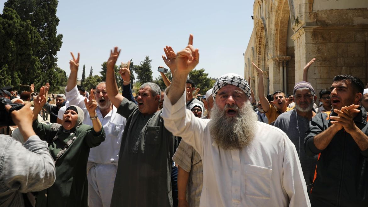 Palestinians gesture as they shout slogans during clashes with Israeli police on