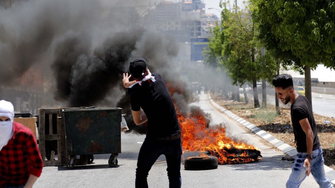 epa07670401 Palestinian protesters during clashes with soldiers at a protest against the expected US peace place at the village of Halhoul, West Bank city of Hebron, 24 June 2019. According to media reports, the US will hold an economic conference in Bahrain on 25 and 26 June, trying to promote investments in the Palestinians territories as the first part of the Middle East peace plan named also 'Deal of the Century'. Palestinian officials are boycotting the deal and have refused to engage with its Middle East peace plan. EPA-EFE/