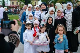 مجموعة من النساء والأطفال يتقطون الصور بعد صلاة العيد