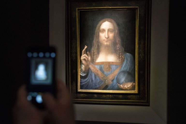 NEW YORK, NY - NOVEMBER 15: A visitor takes a photo of the painting 'Salvator Mundi' by Leonardo da Vinci at Christie's New York Auction House, November 15, 2017 in New York City. The coveted painting is set to be auctioned off on Wednesday night and has been guaranteed to sell for over $100 million.(Drew Angerer/Getty Images)== FOR NEWSPAPERS, INTERNET, TELCOS & TELEVISION USE ONLY ==