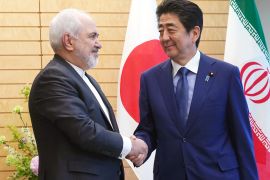 Iranian Foreign Minister Mohammad Javad Zarif, left, and Japanese Prime Minister Shinzo Abe, right, shake hands at Abe's official residence in Tokyo Thursday, May 16, 2019. Eugene Hoshiko/Pool via REUTERS