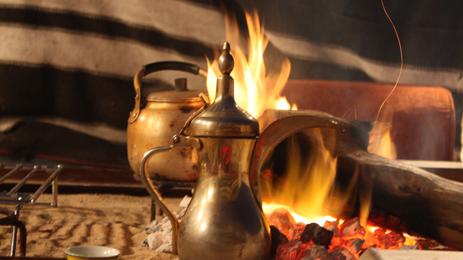 ‪دلة قهوة قطرية على النار، وتفضل دول الخليج القهوة الصفراء الفاتحة بعد التحميص الخفيف مع الزنجبيل والزعفران والقرنفل‬ (مواقع التواصل)