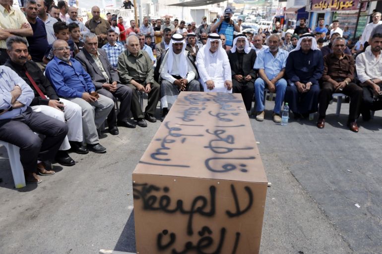 epa07670465 Palestinians sit around the mock coffin with Arabic words reading "No to the deal of the century", during a protest against a US-led meeting this week in Bahrain on the Palestinian-Israeli conflict, in the village of Yatta near the West Bank city of Hebron, 24 June 2019. According to media reports, the U.S. will hold an economic conference in Bahrain on June 25-26, trying to promote investments in the Palestinians territories as the first part of the Middle East peace plan named also "Deal of the Century". Palestinian officials are boycotting the deal and have refused to engage with its Middle East peace plan.