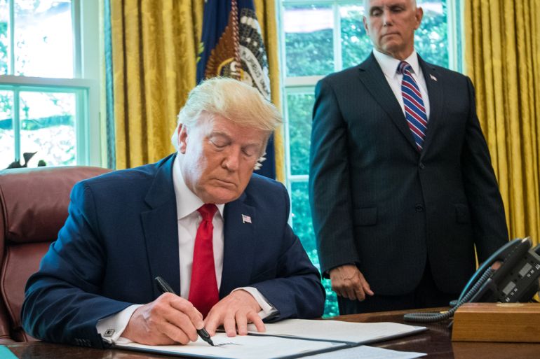 epa07670857 US President Donald J. Trump signs an executive order for additional sanctions against Iran and its leadership, it in the Oval Office at the White House in Washington, DC, USA, on 24 June 2019, as US Vice President Mike Pence (R) look on. The sanctions come in the wake of rising tensions in the Middle East including Iran's recent shooting down of a US drone. EPA-EFE/KEVIN DIETSCH / POOL
