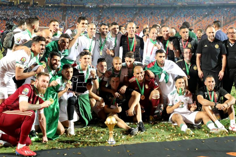 Soccer Football - Africa Cup of Nations 2019 - Final - Senegal v Algeria - Cairo International Stadium, Cairo, Egypt - July 19, 2019 Algeria players and coaches pose with the trophy as they celebrate winning the Africa Cup of Nations REUTERS/Mohamed Abd El Ghany