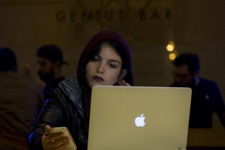 A customer uses an iPhone and a Macbook computer at the Genius Bar in the Apple Store at Grand Central Station in New York April 20, 2015. REUTERS/Brendan McDermid