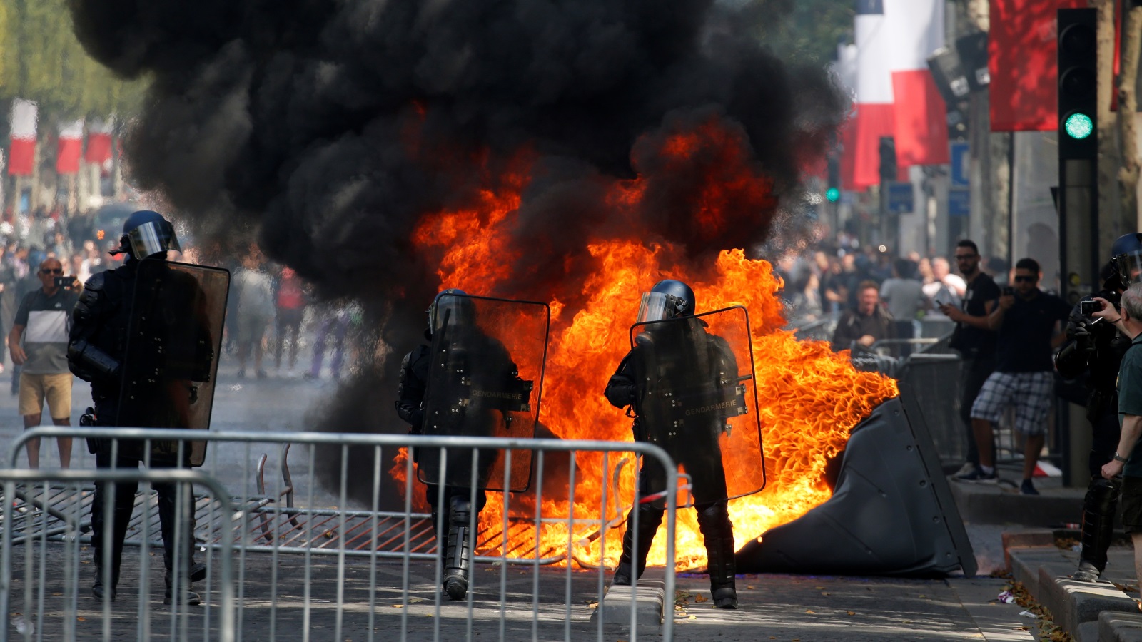 ‪المحتجون من أعضاء السترات الصفراء أضرموا النار في حاويات بالشانزيليزيه‬ (رويترز)