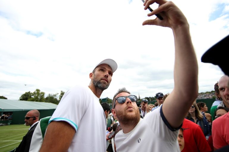 Tennis - Wimbledon - All England Lawn Tennis and Croquet Club, London, Britain - July 1, 2019 Croatia's Ivo Karlovic poses for a selfie with a fan after his first round match against Italy's Andrea Arnaboldi REUTERS/Carl Recine