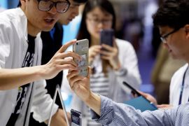 Members of staff talk to visitors at Honor's booth during Global Mobile Internet Conference (GMIC) at the National Convention in Beijing, China April 27, 2018. REUTERS/Damir Sagolj
