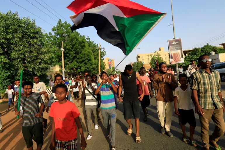 Sudanese people celebrate and wave their national flag, after Sudan's ruling military council and a coalition of opposition and protest groups reached an agreement to share power during a transition period leading to elections, along the street of Khartoum, Sudan, July 5, 2019. REUTERS/Mohamed Nureldin Abdallah