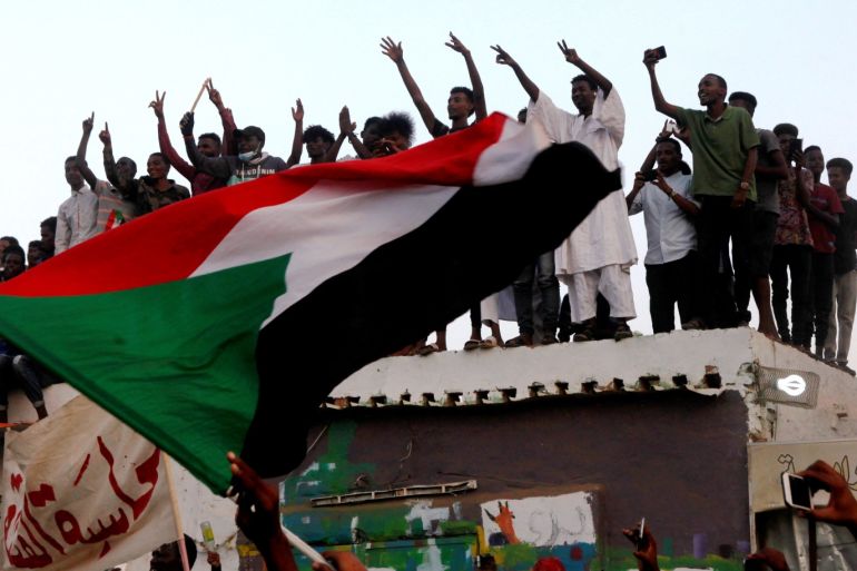 Sudanese people chant slogans and wave their national flag as they celebrate, after Sudan's ruling military council and a coalition of opposition and protest groups reached an agreement to share power during a transition period leading to elections, along the streets of Khartoum, Sudan, July 5, 2019. REUTERS/Mohamed Nureldin Abdallah