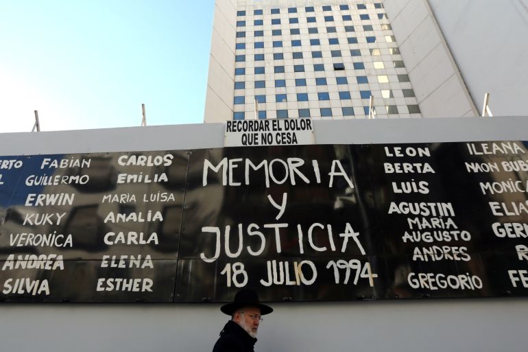 A man walks by a sign that reads "Memory and Justice" next to the names of the victims of the 1994 Argentine Israeli Mutual Association (AMIA) bombing, placed outside the AMIA Jewish community center during commemorations of the 23rd anniversary of the attack in Buenos Aires, Argentina, July 18, 2017. REUTERS/Marcos Brindicci