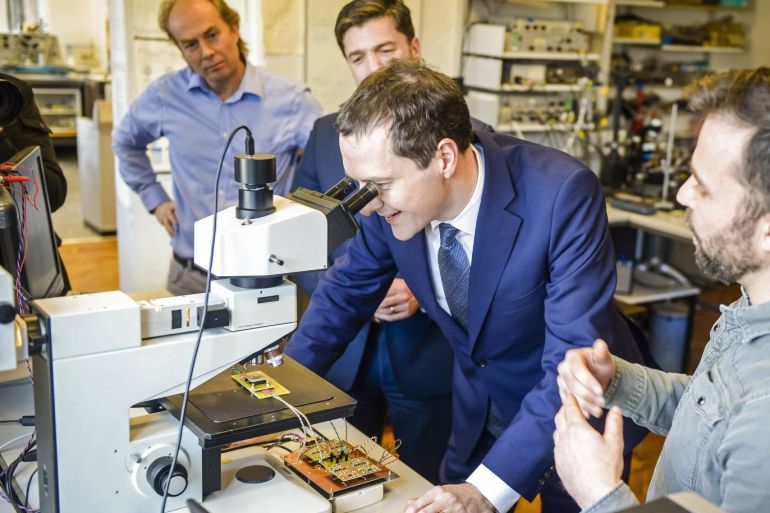 CARDIFF, WALES - JANUARY 07: Chancellor of the Exchequer George Osborne inspects a microchip using a microscope during his visit to the Cardiff School of Physics and Astronomy prior to delivering a speech on January 7, 2016 in Cardiff, Wales. (Photo by Ben Birchall - WPA Pool/Getty Images)