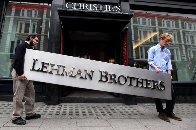 LONDON, ENGLAND - SEPTEMBER 24: Two employees of Christie's auction house manoeuvre the Lehman Brothers corporate logo, which is estimated to sell for 3000 GBP and is featured in the sale of art owned by the collapsed investment bank Lehman Brothers on September 24, 2010 in London, England. The