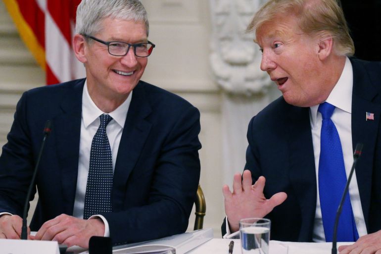 Apple CEO Tim Cook laughs with U.S. President Donald Trump as the news media leave the room after the two men spoke while participating in an American Workforce Policy Advisory Board meeting in the White House State Dining Room in Washington, U.S., March 6, 2019. REUTERS/Leah Millis
