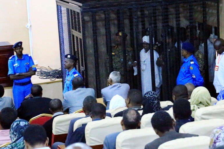 Sudan's former president Omar Hassan al-Bashir stands guarded inside a cage at the courthouse where he is facing corruption charges, in Khartoum, Sudan August 19, 2019. REUTERS/Mohamed Nureldin Abdallah
