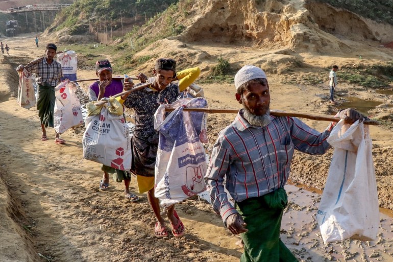 Daily life of Rohingya people in Bangladesh- - COX'S BAZAR, BANGLADESH - JANUARY 12: Rohingya people carry bags at a refugee camp where they, fled from oppression within military operations in Myanmar’s Rakhine state, live in on January 12, 2019 in Cox's Bazar, Bangladesh.
