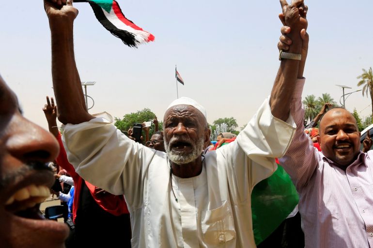 Sudanese people carry their national flag and chant slogans as they celebrate the signing of a constitutional declaration between Deputy Head of Sudanese Transitional Military Council, Mohamed Hamdan Dagalo and Sudan's opposition alliance coalition's leader Ahmad al-Rabiah, outside the Friendship Hall, in Khartoum, Sudan August 4, 2019. REUTERS/Mohamed Nureldin Abdallah TPX IMAGES OF THE DAY