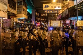 HONG KONG, CHINA - AUGUST 14: Police hold up a warning banner as they charge on a street to disperse protesters during a demonstration on Hungry Ghost Festival day in Sham Shui Po district on August 14, 2019 in Hong Kong, China. Pro-democracy protesters have continued rallies on the streets of Hong Kong against a controversial extradition bill since 9 June as the city plunged into crisis after waves of demonstrations and several violent clashes. Hong Kong's Chief Executive Carrie Lam apologized for introducing the bill and declared it