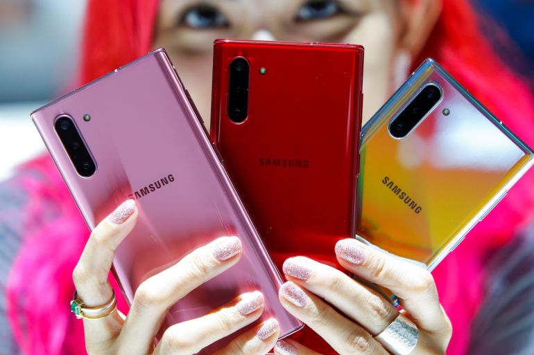 A woman holds different colored models of the Samsung Galaxy Note 10 while people test new devices during the launch event of the Galaxy Note 10 at the Barclays Center in Brooklyn, New York, U.S., August 7, 2019. REUTERS/Eduardo Munoz