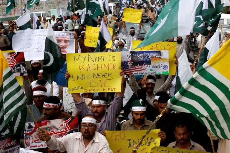 People hold flags and signs in solidarity with the people of Kashmir, during a rally in Karachi, Pakistan August 5, 2019. REUTERS/Akhtar Soomro