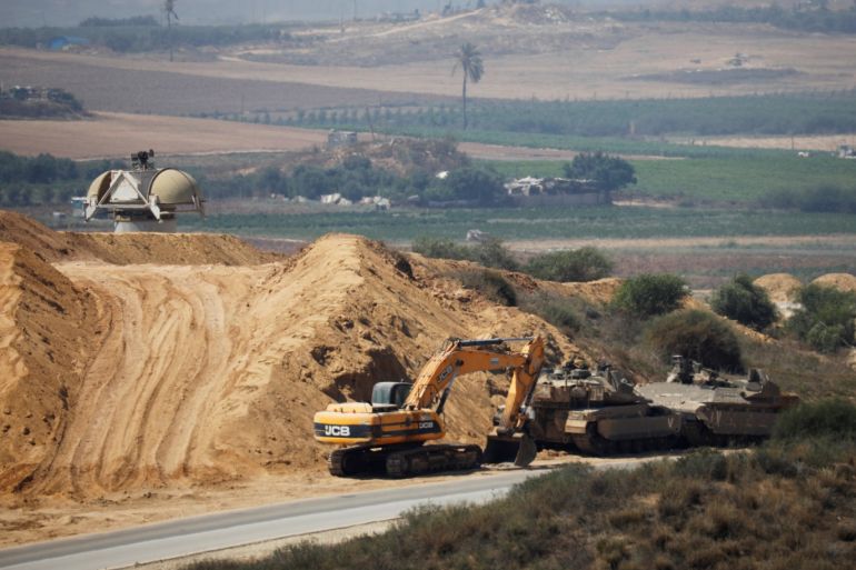 An Israeli military armoured personnel carrier (APC), a tank and a bulldozer are seen next to the border with the Gaza Strip, in southern Israel July 11, 2019. REUTERS/Amir Cohen