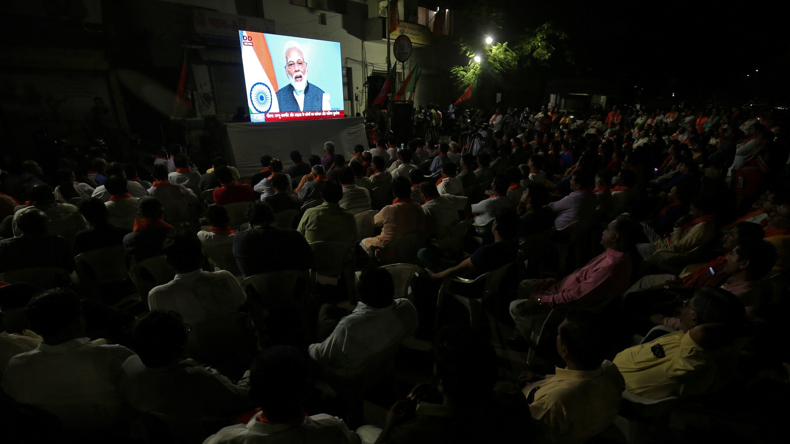 ‪هنود في مدينة أحمد آباد يشاهدون خطابا لرئيس وزرائهم برر فيه قرار نيودلهي إلغاء الحكم الذاتي في إقليم كشمير‬ (رويترز)