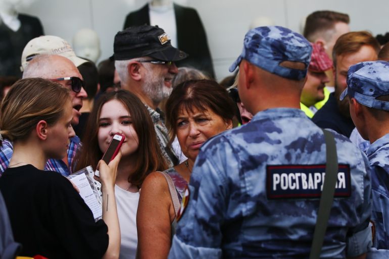 Unauthorized Rally in Moscow- - MOSCOW, RUSSIA - JULY 27: Police officers stand in front of people taking part in an unauthorized rally in support of rejected Moscow City Duma candidates held by Russian opposition in central Moscow, Russia on July 27, 2019.