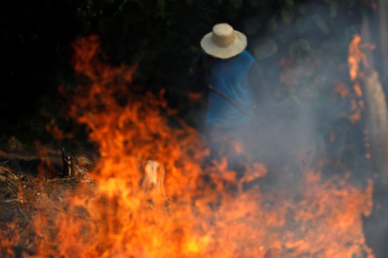 A man works in a burning tract of Amazon jungle as it is being cleared by loggers and farmers in Iranduba, Amazonas state, Brazil August 20, 2019. REUTERS/Bruno Kelly