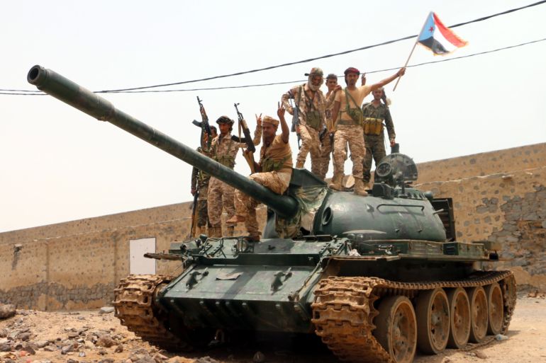 epa07766729 Armed members of a separatist southern group hold up a separatist flag as they stands on a tank during clashes with government forces in the southern port city of Aden, Yemen, 10 August 2019. According to reports, separatist forces in southern Yemen, backed by the United Arab Emirates, have seized all military bases belonging to the Saudi-backed Yemeni government in the southern city of Aden after four days of fighting between the two sides. EPA-EFE/NAJEEB ALMAHBOOBI