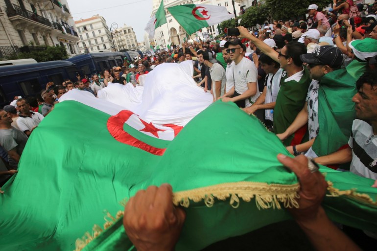 Demonstrators carry flags during a protest demanding the removal of the ruling elite in Algiers, Algeria August 2, 2019. REUTERS/Ramzi Boudina