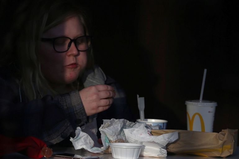 A woman eats her purchases in a window of a McDonald's restaurant in London, Britain December 9, 2016. REUTERS/Neil Hall