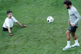 Soccer Football - UEFA Super Cup - Liverpool Training - Vodafone Park, Istanbul, Turkey - August 13, 2019 Liverpool's Mohamed Salah plays football with a child during training REUTERS/Murad Sezer