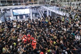 HONG KONG, CHINA - AUGUST 13: An injured man who was suspected of being an undercover police officer, is surround the protesters at Hong Kong International Airport during a demonstration on August 13, 2019 in Hong Kong, China. Pro-democracy protesters have continued rallies on the streets of Hong Kong against a controversial extradition bill since 9 June as the city plunged into crisis after waves of demonstrations and several violent clashes. Hong Kong's Chief Executi