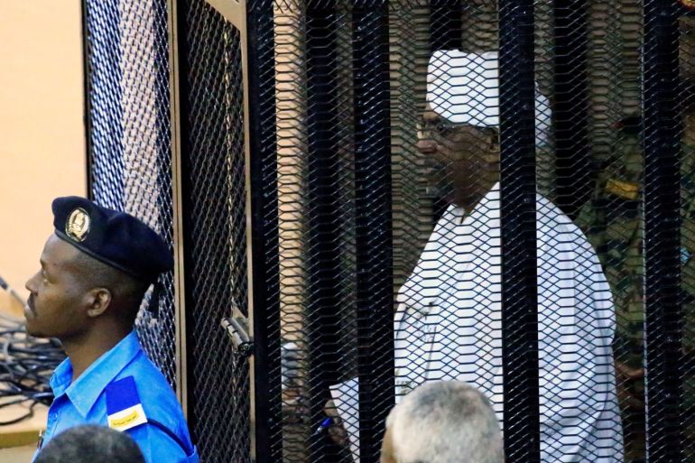 Sudan's former president Omar Hassan al-Bashir stands guarded inside a cage at the courthouse where he is facing corruption charges, in Khartoum, Sudan August 19, 2019. REUTERS/Mohamed Nureldin Abdallah