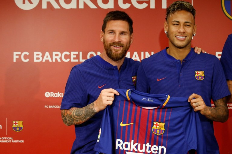 FC Barcelona players Lionel Messi (L) and Neymar holding their uniforms pose for a photo during a news conference to announce the sponsorship deal between the team and Japanese e-commerce operator Rakuten Inc. in Tokyo, Japan July 13, 2017. REUTERS/Kim Kyung-Hoon