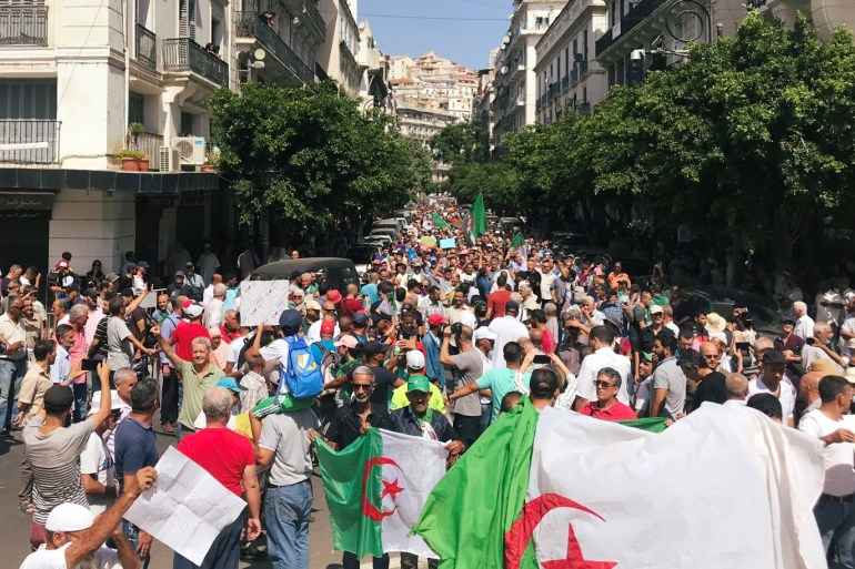 Demonstrators carry flags and banners during a protest demanding the removal of the ruling elite in Algiers, Algeria September 10, 2019. REUTERS/Abdelaziz Boumzar