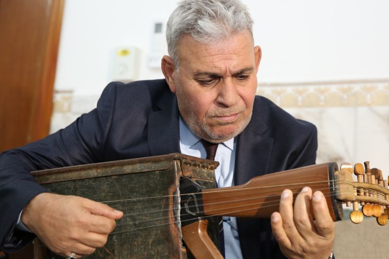 Iraqi teacher transforms kalashnikov rifle into musical instrument- - BAGHDAD, IRAQ - SEPTEMBER 18: Iraqi music teacher Macid Qazim, poses for a photo with his musical instrument in Baghdad, Iraq on September 18, 2019. Qazim transformed his kalashnikov rifle into a stringed musical instrument and he stated that I want to give peace messages to the whole world from my war tired country.