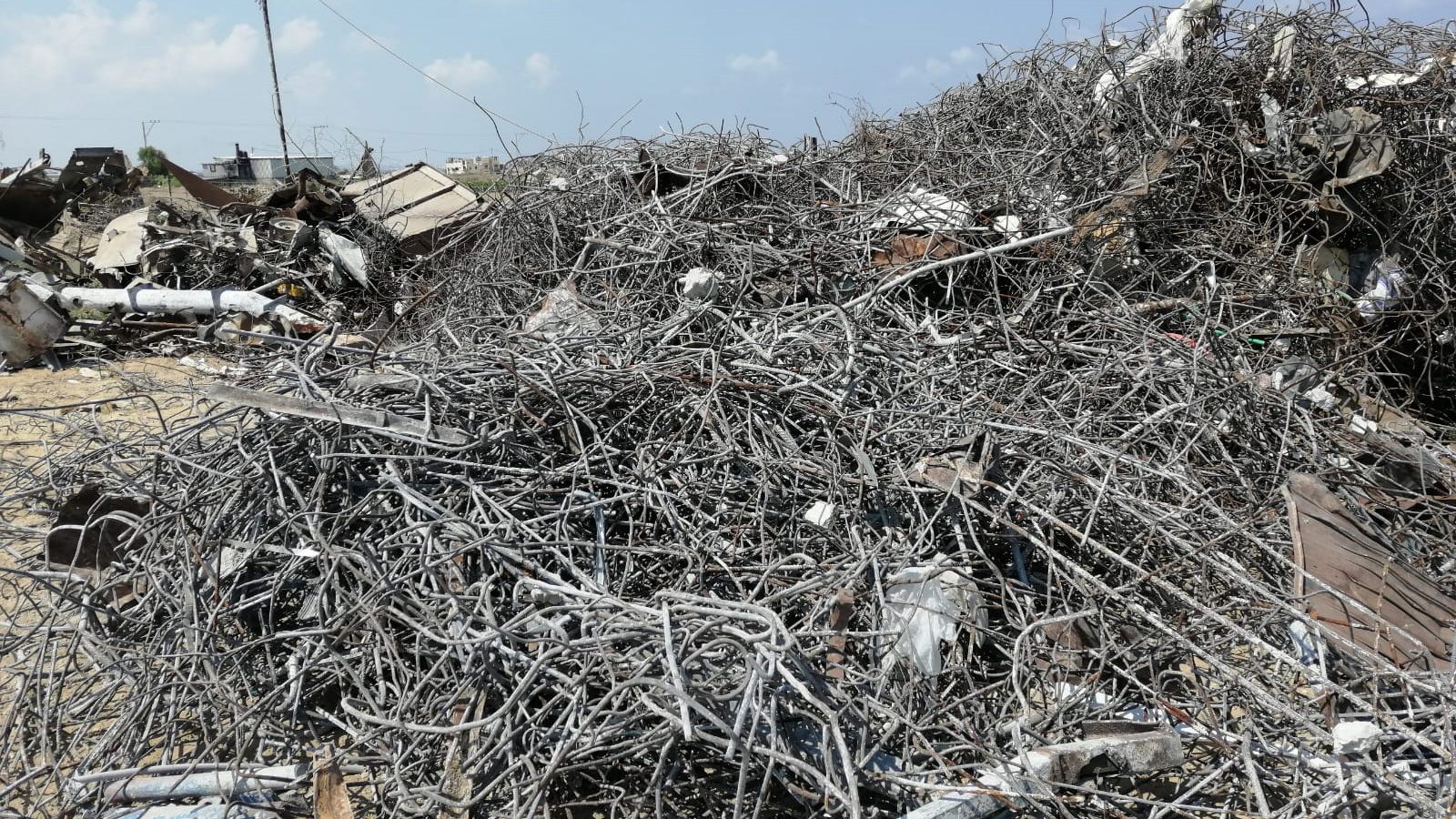 ‪أكوام عملاقة من قضبان الحديد تم استخراجها من ركام عشرات المنازل والمنشآت التي دمرتها غارات إسرائيلية‬ (الجزيرة)