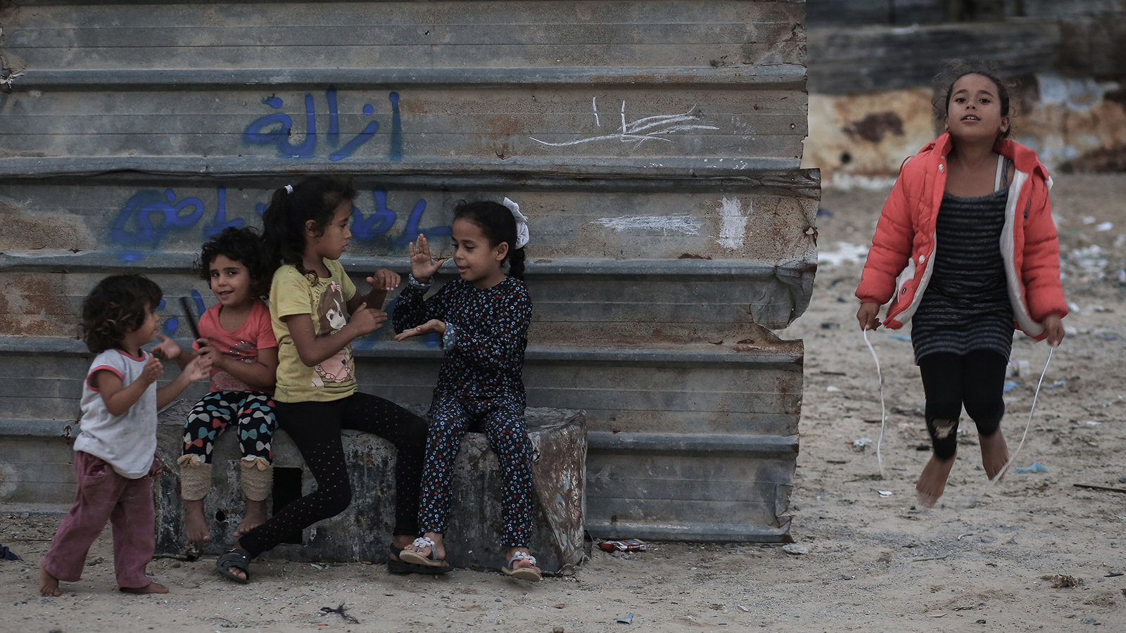 أطفال يلعبون بالقرب من منزلهم الملاصق لمكب نفايات في مدينة خانيونس (الجزيرة)