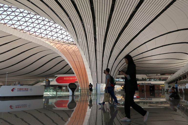 Journalists walk at the terminal hall after the launching ceremony for the new Daxing International Airport ahead of the 70th founding anniversary of the People's Republic of China in Beijing, China September 25, 2019. REUTERS/Thomas Suen