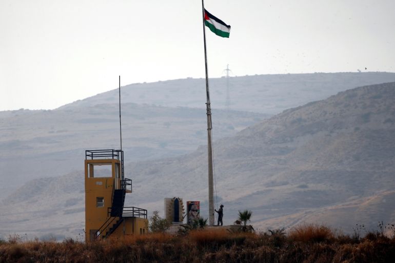 A Jordanian soldier pulls a Jordanian national flag in an outpost at the border area between Israel and Jordan at Naharayim, as seen from the Israeli side October 22, 2018. REUTERS/ Ronen Zvulun